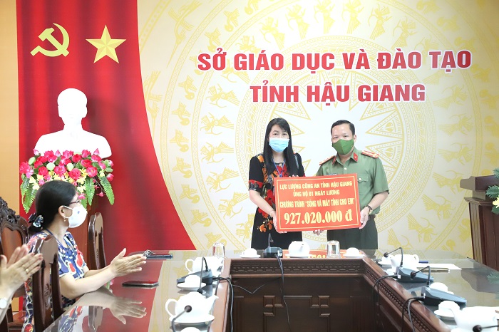 Đại tá Nguyễn Văn Thắng, Phó Giám đốc Công an tỉnh Hậu Giang trao tiền ủng hộ Chương trình “Sóng và máy tính cho em” cho lãnh đạo Sở Giáo dục và Đào tạo tỉnh Hậu Giang