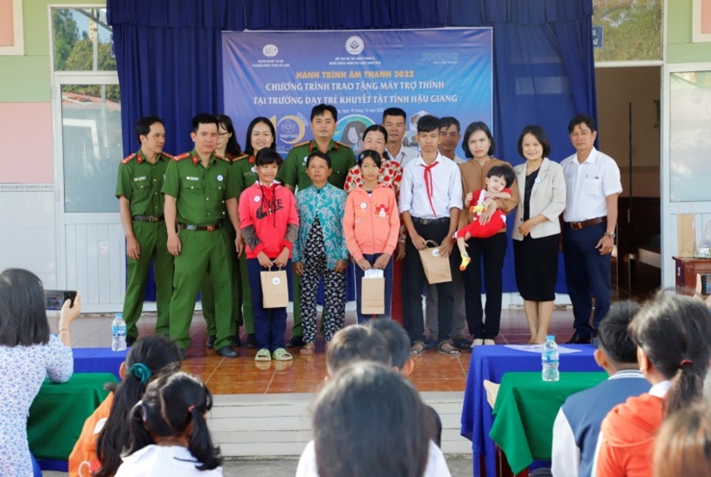 Phòng Cảnh sát hình sự, Hội cha mẹ trẻ khiếm thính Việt Nam và Ban Giám hiệu nhà Trường chụp ảnh lưu niệm cùng đại diện gia đình và các em khiếm thính được tặng máy trợ thính