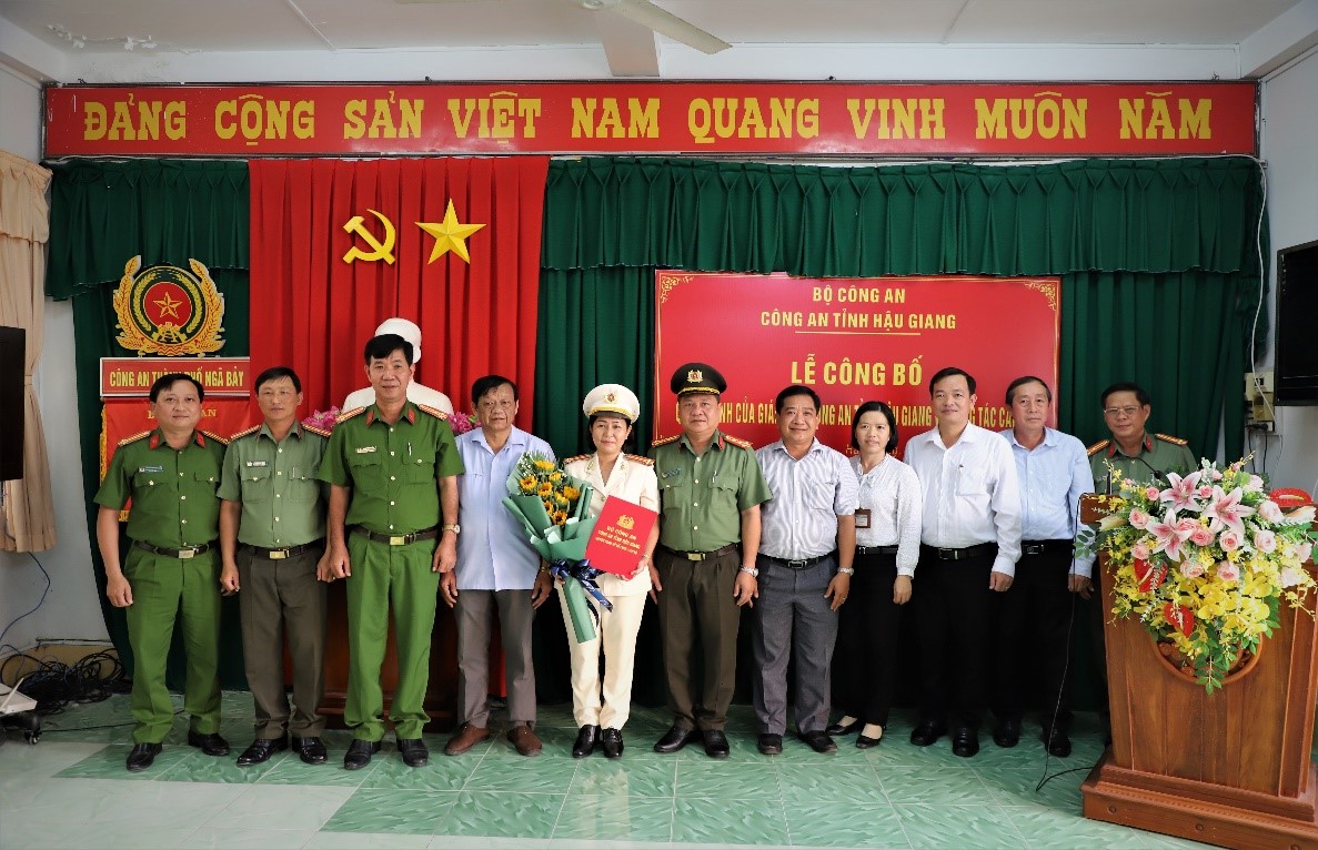 Tập thể Lãnh đạo tặng hoa và chụp ảnh lưu niệm cùng đồng chí Trung tá Đỗ Thị Thanh Tuyền, Phó Trưởng Công an thành phố Ngã Bảy